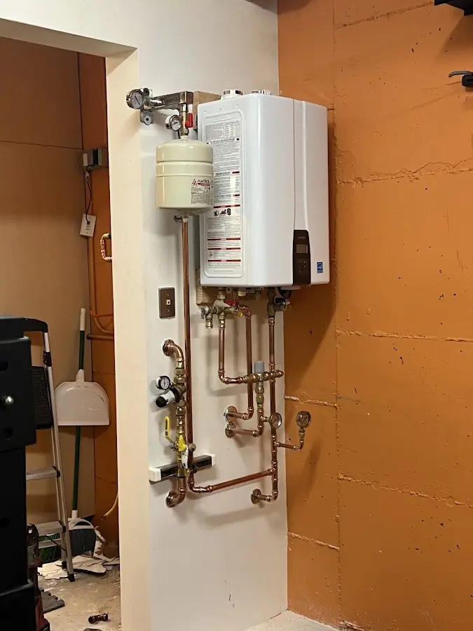 Plumbing technician inspecting water heater connections in Waynesville